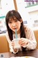 A woman sitting at a table with a glass of milk.