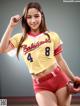 A woman in a baseball uniform posing for a picture.