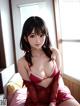 A woman in a red lingerie sitting on a bed.