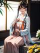 A woman in a kimono sitting on a bench next to flowers.