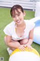 A woman sitting on top of a yellow and white ball.