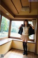 A woman standing in front of a window in a room.